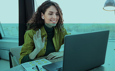 Frau mit Kopfhörern im Call vor einem Laptop